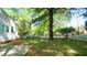 Backyard view featuring a large tree, a well-kept lawn, and a white picket fence at 409 Green St, Sanford, NC 27330
