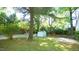 Lush backyard with green grass, a storage shed, brick retaining wall, and white picket fence at 409 Green St, Sanford, NC 27330