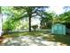 Backyard featuring a well-manicured lawn, shed with double doors, and a paved patio at 409 Green St, Sanford, NC 27330