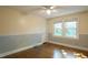 Cozy bedroom features hardwood floors, wainscoting, a ceiling fan, and two sunny windows at 409 Green St, Sanford, NC 27330
