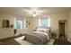 This bedroom features light yellow walls, a ceiling fan, and is staged with neutral furniture and décor at 409 Green St, Sanford, NC 27330