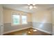 Comfortable bedroom featuring hardwood floors, wainscoting, a ceiling fan, and two sunny windows at 409 Green St, Sanford, NC 27330
