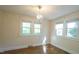 Bedroom with hardwood floors, chandelier, and three bright windows providing natural light at 409 Green St, Sanford, NC 27330