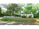 Inviting single-story home with a brick walkway, green lawn, and white picket fence under mature shade trees at 409 Green St, Sanford, NC 27330