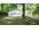 A well-manicured front yard featuring a classic home, a mature tree, and a white picket fence at 409 Green St, Sanford, NC 27330