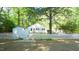Charming home featuring a white picket fence, light blue shutters, and mature trees at 409 Green St, Sanford, NC 27330