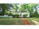 Inviting front yard featuring a charming cottage-style home with a brick walkway and a white picket fence at 409 Green St, Sanford, NC 27330