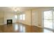Living room with hardwood floors, a ceiling fan, a white fireplace, and bright light at 409 Green St, Sanford, NC 27330