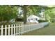 Well-maintained yard with a white picket fence and mature trees, offering privacy and charm at 409 Green St, Sanford, NC 27330