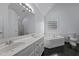 Elegant bathroom with a double vanity, soaking tub, separate shower, and a decorative glass block window at 411 Westhampton Dr, Burlington, NC 27215