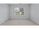 Sunlit bedroom featuring a large window with blinds, creating a bright and airy ambiance, and neutral carpet at 411 Westhampton Dr, Burlington, NC 27215