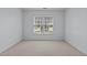 Cozy bedroom with neutral carpet flooring and a large window providing natural light at 411 Westhampton Dr, Burlington, NC 27215