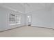 Bright bedroom with a tray ceiling, large windows, and neutral carpet flooring at 411 Westhampton Dr, Burlington, NC 27215