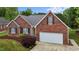 Charming red brick home showcasing a manicured lawn and an attached garage at 411 Westhampton Dr, Burlington, NC 27215