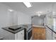 Spacious kitchen with hardwood floors, stainless steel oven, and granite countertops overlooking the living area at 411 Westhampton Dr, Burlington, NC 27215