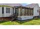 Charming sunroom with glass walls, accessible by wooden stairs, seamlessly connecting indoor and outdoor living at 411 Westhampton Dr, Burlington, NC 27215