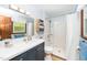 Bathroom features a blue vanity with white countertop and shower with glass doors at 4418 Carpenter Pond Rd, Durham, NC 27703