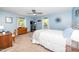 Light blue bedroom with a white comforter, wood furniture and natural light from the windows at 4418 Carpenter Pond Rd, Durham, NC 27703
