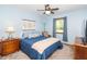 Light blue bedroom with a blue comforter, wood furniture and natural light from the windows at 4418 Carpenter Pond Rd, Durham, NC 27703