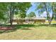 Brick house with front porch shaded by trees, nestled on a lush lawn at 4418 Carpenter Pond Rd, Durham, NC 27703