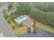 Aerial view of community pool, clubhouse, landscaping, and parking lot surrounded by trees at 47 Scarlet Bell Dr, Youngsville, NC 27596