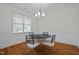 Dining room with hardwood floors, chandelier, and modern black and white chairs at 47 Scarlet Bell Dr, Youngsville, NC 27596