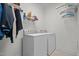 Functional laundry room featuring a full-sized washer and dryer with storage shelves at 47 Scarlet Bell Dr, Youngsville, NC 27596