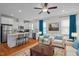 Bright and airy open-concept living room and kitchen featuring a hardwood floor, white cabinets, and white walls at 47 Scarlet Bell Dr, Youngsville, NC 27596
