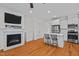Bright living room featuring a fireplace, television, and kitchen island with bar stool seating at 47 Scarlet Bell Dr, Youngsville, NC 27596