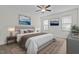 Well-lit main bedroom featuring neutral walls, a ceiling fan, large windows, and a plush queen-sized bed at 47 Scarlet Bell Dr, Youngsville, NC 27596