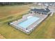 Aerial view of community pool and clubhouse surrounded by green space on a rainy day at 47 Scarlet Bell Dr, Youngsville, NC 27596