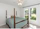 Bright bedroom features a four-poster bed and a view of the front yard at 4908 Birkenhead Ct, Apex, NC 27539