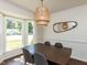 Warm dining room featuring a modern chandelier, dining table, and large windows at 4908 Birkenhead Ct, Apex, NC 27539