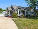 Charming gray home with a well-manicured lawn, inviting curb appeal, and a concrete driveway at 4908 Birkenhead Ct, Apex, NC 27539