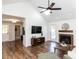 Open-concept living room featuring wood floors, skylights, and a brick fireplace at 4908 Birkenhead Ct, Apex, NC 27539