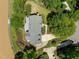 An aerial view of a house with a patio and lush landscaping bordering a lake at 5 Bobby Parker Pl, Durham, NC 27703
