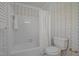 Bright bathroom with a white tub, shower, toilet, and floral wallpaper at 5 Bobby Parker Pl, Durham, NC 27703