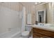 Cozy bathroom with floral wallpaper, a vanity, and a bathtub with shower at 5 Bobby Parker Pl, Durham, NC 27703