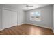 Bedroom with a closet, hardwood floors and a shuttered window overlooking the water at 5 Bobby Parker Pl, Durham, NC 27703