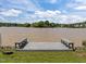 Scenic view of a serene lake from a private dock with built in benches and lush green surroundings at 5 Bobby Parker Pl, Durham, NC 27703