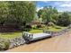 Picturesque waterfront with a private dock, lush greenery, and a charming house in the background at 5 Bobby Parker Pl, Durham, NC 27703
