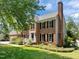 Charming two-story brick home with a chimney, professional landscaping, and black shutters at 5 Bobby Parker Pl, Durham, NC 27703