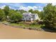 Exterior view of a home with manicured lawn and lake access, surrounded by mature trees at 5 Bobby Parker Pl, Durham, NC 27703