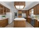 Classic kitchen design featuring wood cabinets, an island, stainless steel appliances, and neutral countertops at 5 Bobby Parker Pl, Durham, NC 27703