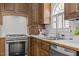 Close-up view of the kitchen featuring stainless steel appliances, wood cabinets, and a sink with a view at 5 Bobby Parker Pl, Durham, NC 27703