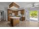 Well-lit kitchen with wood cabinetry, a center island, and access to an outdoor deck through glass doors at 5 Bobby Parker Pl, Durham, NC 27703