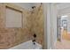 Ceramic tiled bath and shower with a built-in shampoo shelf, accompanied by matte black fixtures at 503 Belmont Cir, Wake Forest, NC 27587