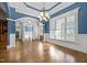 Dining room with hardwood floors, chandelier, wainscoting, blue accent walls and large windows at 503 Belmont Cir, Wake Forest, NC 27587