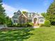 Stunning front exterior featuring a mix of brick and siding, complimented by lush landscaping at 503 Belmont Cir, Wake Forest, NC 27587