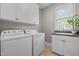 Functional laundry room showcasing a washer and dryer, complemented by upper cabinets, a sink and natural lighting at 503 Belmont Cir, Wake Forest, NC 27587